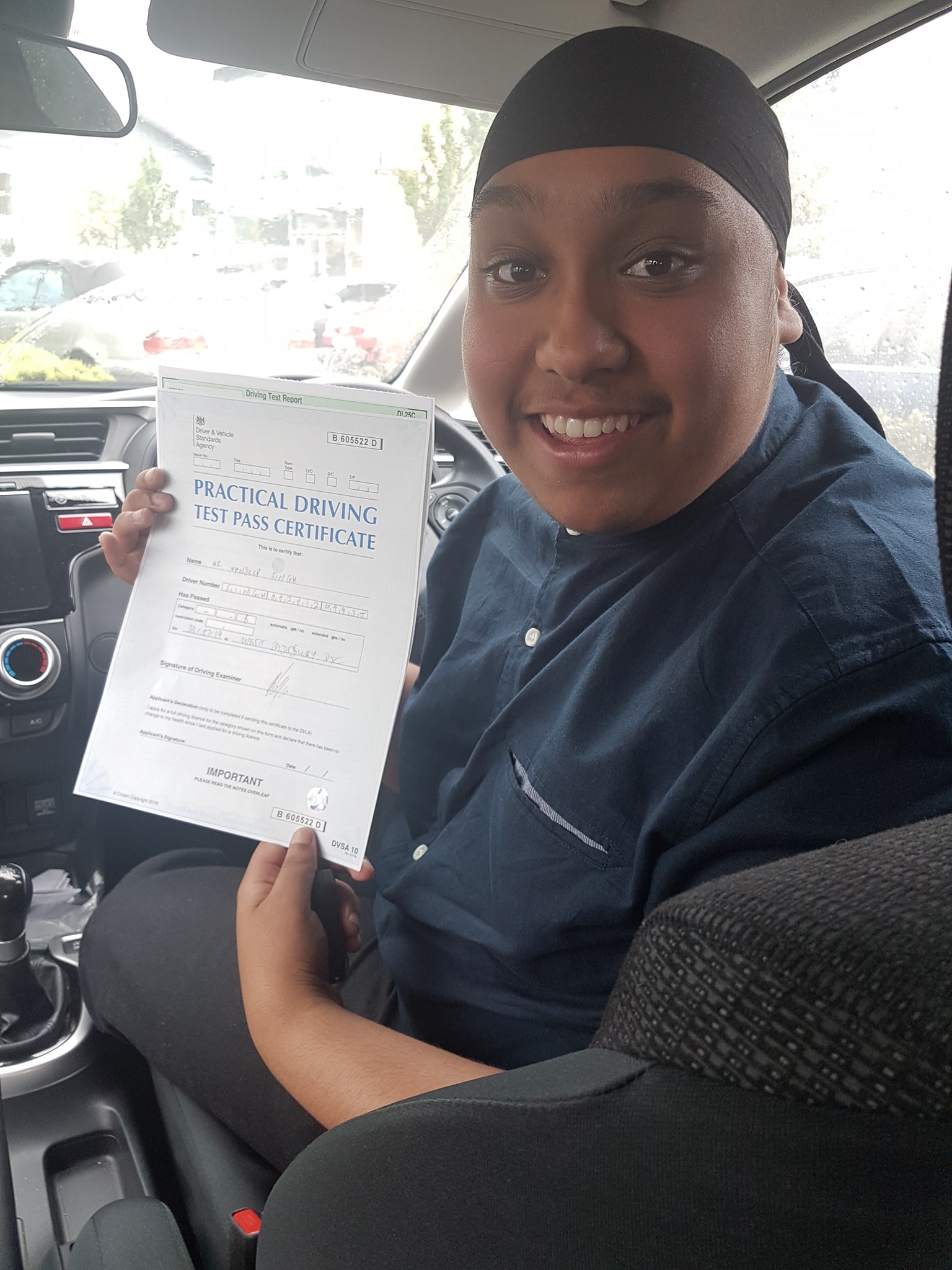 Image of a learner driver showing their test certificate